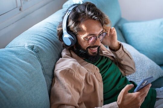 Mann med hodetelefoner bruker en musikkapp på mobilen